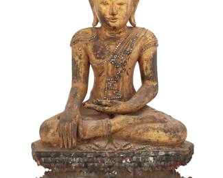 398 A Southeast Asian carved giltwood Buddha Rattanakosin Period (1782-1932) With hands in Bhumisparsha mudra, decorated with inset glass accents, raised on a double lotus base 25" H x 17.75" W x 9.75" D Estimate: $2,000 - $3,000