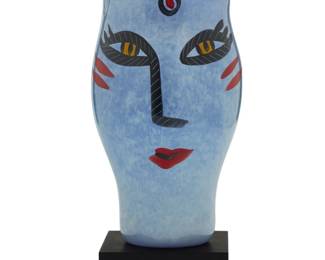 226 Ulrica Hydman-Vallien (1938-2018) An "Open Minds" painted glass vase for Kosta Boda, late 20th century Etched to underside: Kosta Boda / [indecipherable] / Ulrica H.V / 48744; painted at base: Ulrica HV/LP; with applied factory labels Raised on a painted wood plinth Glass: 10.75" H x 5.625" Dia.; Plinth: 2" H x 4.5" W x 4.5" D Estimate: $200 - $300