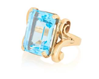 96 A 14K Gold and Blue Topaz Ring Centering an emerald-cut blue topaz weighing approximately 8.50 carats  Size: 7 1/2 10.6 grams gross Estimate: $1,000 - $1,500