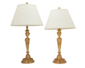 333 A near pair of Louis XVI style gilt bronze candlestick lamps E.F. Caldwell & Co., New York and Maison Gagneau & Cie. Paris, late 19th century One incised to base: E. F. Caldwell & Co. Inc New York.; the other incised: Gagneau & Cie Paris Each wired fluted standard cast with bellflower swags and lion masks, one issuing three lights, the other issuing two lights, each surmounted by a fabric-lined paper shade, electrified 2 pieces Taller lamp: 33.75" H x 7.5" Dia.; Shorter: 30.25" H x 7.75" Dia.; Each shade: 10.5" H x 17.5" Dia. Estimate: $800 - $1,200