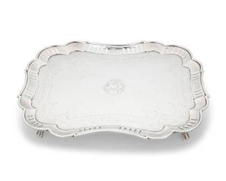 204 A George III sterling silver shaped rectangular salver Likely William Eley & William Fearn, London, 1801 With impressed standard, city, date letter, George III, and maker's marker: WE [rubbed] / WF With scalloped and pierced rim, centered by an armorial, raised on four feet 1.625" H x 12" W x 9.5" D 22.8 oz. troy approximately Estimate: $600 - $800