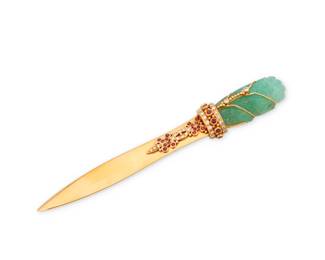 66 An 18K Gold, Emerald, Ruby and Diamond Letter Opener Featuring a shortened 18k gold blade topped by a foliate carved emerald, embellished by an ornate gold motif set with round rubies and diamonds  Measures: 5 1/2 x 3/4 in. 55.2 grams Estimate: $6,000 - $8,000