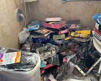 Hundreds of unused wigs in packets 