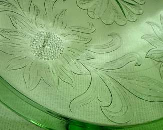 This set includes a green Jeannette Glass "Sunflower" cake plate and Anchor Hocking bowl. The cake plate features a prominent sunflower design with swirling leaves and a three-toed base.