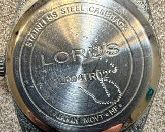 This lot contains two women's quartz wristwatches. The first is a Lorus watch with a silver-tone dial, silver-tone metal band, and a stainless steel caseback. It features a simple dial with hour markers and Arabic numerals at 12 and 6 o'clock. The second is a Milan watch with a champagne-colored dial, gold-tone bezel, and a two-tone metal band. It is marked as 'DIAMOND QUARTZ' and has a stainless steel back with a base metal bezel. Both watches appear to be functional quartz movements, suitable for everyday wear.