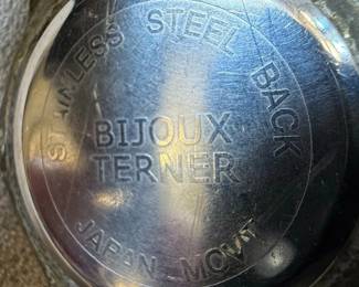 This lot features two distinct wristwatches. The first is a Timex watch with a silver-tone dial, Arabic numerals, and 'WATER RESISTANT' marking. It has a metal expansion band and a base metal bezel with a stainless steel back, assembled in the Philippines. The second is a Bijou Terner quartz watch with a white dial, featuring a Swiss cross emblem at the 12 o'clock position, Arabic numerals, and 24-hour markings. It is marked 'JAPAN MOVT' and 'STAINLESS STEEL BACK'. Both watches show signs of wear consistent with age and use.