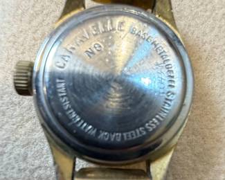 This lot features two women's wristwatches: a gold-tone Pulsar with a mother-of-pearl dial and a silver-tone Caravelle with a white dial. The Pulsar watch has an oval case and a multi-link bracelet, with 'PULSAR', 'WATER RESISTANT', 'ST. STEEL', '1N00-X139 R2', 'MOVEMENT JAPAN', and '500106' visible on the case back. The Caravelle watch has a round case, Roman numerals, and a metal expansion band, with 'CARAVELLE', 'WATER RESISTANT', and 'T SWISS T' visible on the dial. Both appear to be quartz-powered and show signs of wear consistent with age and use.