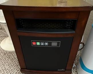 This is a portable infrared quartz heater manufactured by Duraflame, featuring a wooden cabinet with a dark cherry finish designed to resemble furniture. It has a black front panel with a digital display and control buttons. The heater is identified by the model number 10QI071ARA and operates on 120V, 1500W, 60Hz. It is UL listed. The design provides supplemental heat while blending into home decor.