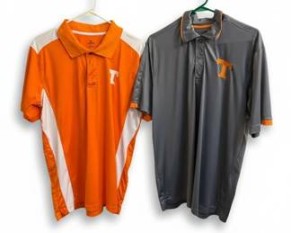 This lot features two short-sleeve polo shirts, both designed with University of Tennessee Volunteers branding. The first shirt is predominantly orange with white and grey accents on the sides and sleeves, featuring a white collar and orange trim. The second shirt is a solid charcoal grey with orange trim on the collar and cuffs, and an orange embroidered 'T' logo. Both shirts are made from a performance-fabric blend, typical for athletic apparel, and are labeled as size Large. The orange shirt is branded 'KA Knights Apparel' and made in Bangladesh, while the grey shirt is from 'Champion Authentic Athleticwear' and also made in Bangladesh.