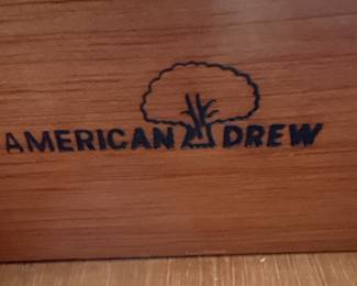 This is a large, traditional china cabinet manufactured by Schwanek Furniture, a company known for its "Fine Interiors" line. The cabinet is constructed from dark-stained wood, likely mahogany or cherry, with a rich, warm finish. It features a multi-paneled glass upper section with decorative mullions forming an intricate diamond pattern, designed to display china and decorative items. The lower section comprises several drawers and cabinets, offering ample storage. The hardware appears to be ornate brass, consistent with traditional furniture styles. The overall aesthetic suggests a piece from the mid to late 20th century, designed to be a focal point in a dining room or living area.