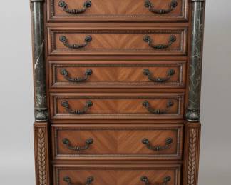 This bedroom set, comprising a tall chest of drawers, a nightstand, and a dresser with a mirror, is crafted from cherry wood with a rich, warm finish. The style is reminiscent of Italian Baroque, characterized by ornate carvings, scrolled hardware, and decorative inlays. Each piece features faux marble columns with detailed capitals and bases, adding a touch of opulence. The dresser top and nightstand top appear to be made of real marble, likely black with white veining, providing a durable and luxurious surface. The intricate detailing on the drawer fronts and the central decorative panel of the dresser suggests a high level of craftsmanship, typical of furniture designed to make a statement.