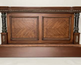 This grand queen size footboard embodies the opulence of Italian Neoclassical design, featuring a rich mahogany wood frame with intricate detailing. The central panel showcases a striking sunburst veneer pattern, meticulously arranged to create depth and visual interest. Flanking the central section are two substantial columns, clad in dark, veined marble, adding a touch of classical gravitas. The overall aesthetic is one of refined elegance, characterized by its symmetrical composition, decorative moldings, and the harmonious blend of wood and stone. This piece would serve as a majestic focal point for a master bedroom, evoking a sense of historical grandeur and sophisticated luxury.