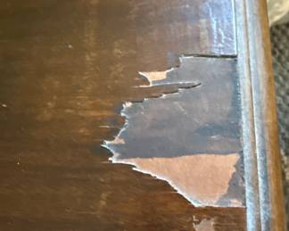 This is a vintage cedar-lined blanket chest, likely dating from the mid-20th century, manufactured by the Lane Company. The exterior is constructed from dark stained wood, possibly walnut, featuring a curved lid and decorative carved or applied molding around the base and an oval motif on the front panel. The interior is lined with aromatic cedar wood, a traditional material for protecting textiles from moths and moisture. The chest has a lock mechanism and is supported by short, carved feet. Its design suggests a piece of functional furniture that also served as a repository for personal belongings. Many Lane cedar chests from this era feature a "Style" number and manufacturing date stamped inside, which can help to further refine the identification.