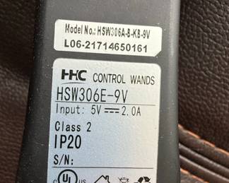 This is a brown, faux leather power lift recliner chair. It features plush, overstuffed cushioning with decorative stitching in a contrasting cream color. The chair is operated by a wired remote control that allows for adjustment of the headrest and back, as well as a lift function, indicated by directional arrows on the remote. The remote also has buttons for headrest and back adjustments, suggesting multiple reclining positions and lumbar support options. The material appears to be a durable, easy-to-clean faux leather, suitable for everyday use. The overall design is contemporary and emphasizes comfort and ease of use, particularly for individuals who may require assistance with standing or sitting.