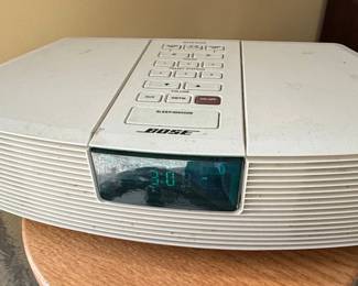 The Bose Wave Radio Model AWR1-1W is a compact, all-in-one audio system known for its distinctive design and Bose's proprietary sound-enhancing technology. It features a prominent digital display, tactile control buttons for tuning, volume, and playback, and a slot for CD insertion. The unit is constructed primarily from durable plastic, with a ribbed front grille that contributes to its acoustic performance. This model includes AM/FM radio reception and a CD player, with an AUX input for external devices. Its compact size and integrated sound reproduction made it a popular choice for bedside tables or small living spaces. This specific model is the AWR1-1W.