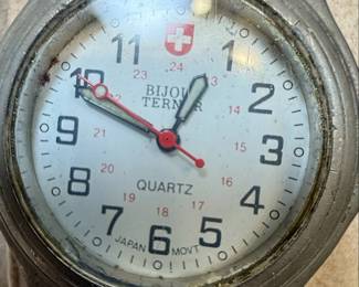 This lot features two distinct wristwatches. The first is a Timex watch with a silver-tone dial, Arabic numerals, and 'WATER RESISTANT' marking. It has a metal expansion band and a base metal bezel with a stainless steel back, assembled in the Philippines. The second is a Bijou Terner quartz watch with a white dial, featuring a Swiss cross emblem at the 12 o'clock position, Arabic numerals, and 24-hour markings. It is marked 'JAPAN MOVT' and 'STAINLESS STEEL BACK'. Both watches show signs of wear consistent with age and use.