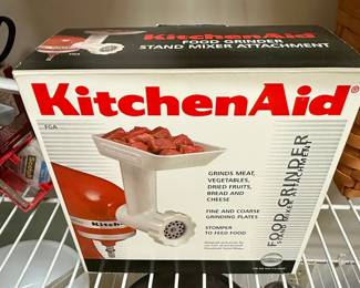 This is a KitchenAid Food Grinder attachment, model FGA, designed to be used with all KitchenAid household stand mixers. It is capable of grinding meat, vegetables, dried fruits, bread, and cheese, and comes with fine and coarse grinding plates. The attachment includes a stomper for feeding food into the grinder. The packaging indicates it is designed exclusively for KitchenAid stand mixers.