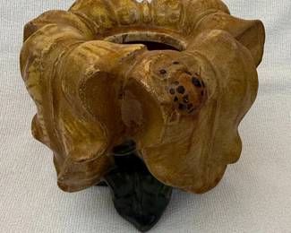 This vintage ceramic piece is designed to resemble a blooming flower, possibly a dahlia or chrysanthemum, with ruffled petals in a mottled tan and gold glaze. A small, dark ladybug is incorporated into the design on one of the petals. The base features a dark green leaf element. The interior shows a simpler, unglazed ceramic finish. The overall aesthetic suggests a decorative pot or planter, likely from the mid to late 20th century, with a whimsical, nature-inspired theme. The glaze has a semi-gloss finish, and there are signs of age and use consistent with a vintage item.