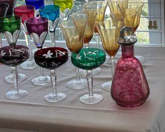 Baccarat Genova stemware on the left, Vintage Cranberry glass decanter, front Nachtman Taube cut to clear glass Champagne glasses, also Bohemian Iridized trumpet wine glasses 