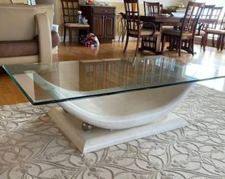 Large sculptural coffee table (60" x 35") with architectural curved pedestal base and thick glass top. 