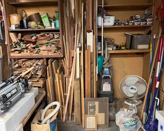 A Porter-Cable power tool is off to the left, as well as a collection of small wood pieces.  A vacuum cleaner and other miscellaneous tools are here.