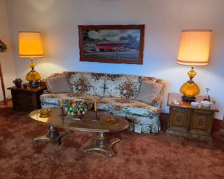 Mid century furniture, including a vintage sofa, coffee table, end tables, lamps, and art