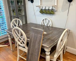 Liberty furniture Magnolia Manor, dining set, table with four splat back chairs, weathered brownish gray top with an antique white finish measures 41 inches wide by 57 inches long by 30 inches tall. Has an additional leaf.