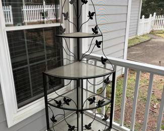 C74 - $65. Vintage Corner 4 Tier Metal Plant Stand with Glass Shelves and Ivy Leaf Accents. Magnetic doors on the bottom do not stick (easy repair) and some chipping paint. Has been used on screened in porch. Measures 29" wide x 20.5" deep x 64" tall. 