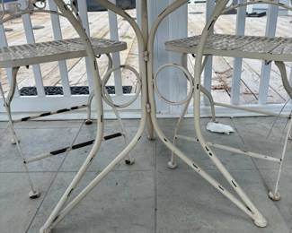 C76 - $40. Vintage Style White Wrought Iron Bistro Set that folds. Includes a round table and two matching chairs. Table is 24" x 26.25" tall. Chairs are 15.5" wide x 14" deep x 34" tall. Floor to seat is 17.25" Tall. 