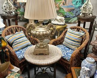 Pair of iron end tables with eggshell mosaic tops by Maitland Smith, Silvergilt urn form Italian lamp, Pair of woven wicker armchairs, and more.