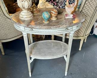 Painted Louis XVI style oval occasional table with caned stretcher and faux top
