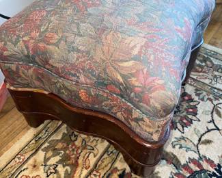Vintage footstool with floral tapestry fabric on a dark wood base