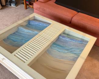 Beautiful coffee table with beach scene under the glass.