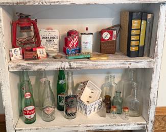 Collection of soda bottles - Dr Pepper, Mountain Dew, Pepsi Co; Dietz kerosene lantern; Vintage matchbooks; Rain Gauge Advertisement for Jack H. Choate Agency; Vintage Radio Shack battery chekcer; Mobil Handy Oil Tin Can; 
