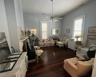 Several white wicker pieces, floral couch, large mirrors, and more