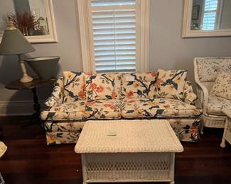 Floral pattered couch, white wicker storage bench