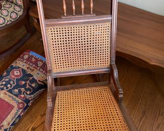 #21 Carved wood antique rocking chair w cane back and seat. Good condition $ 75.00