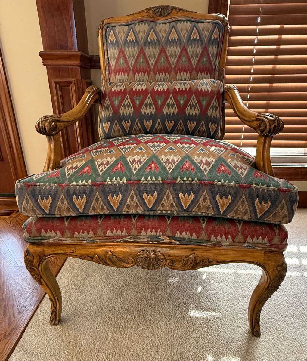 Antique Louis XV style carved upholstered armchair, circa early 20th century, will add a classic touch to any contemporary style.  It is upholstered in a flame stitch fabric and has down filled cushion.  The wood frame has carved details, the most prominent being a flower on the top of the chair, and then continues to the arms and legs.  It's a unique and comfy accent chair for any living space.   Great condition  Measures 24" wide, 29" deep, 39” tall, 21" seat width, 24” seat depth, 19" seat height.  $450