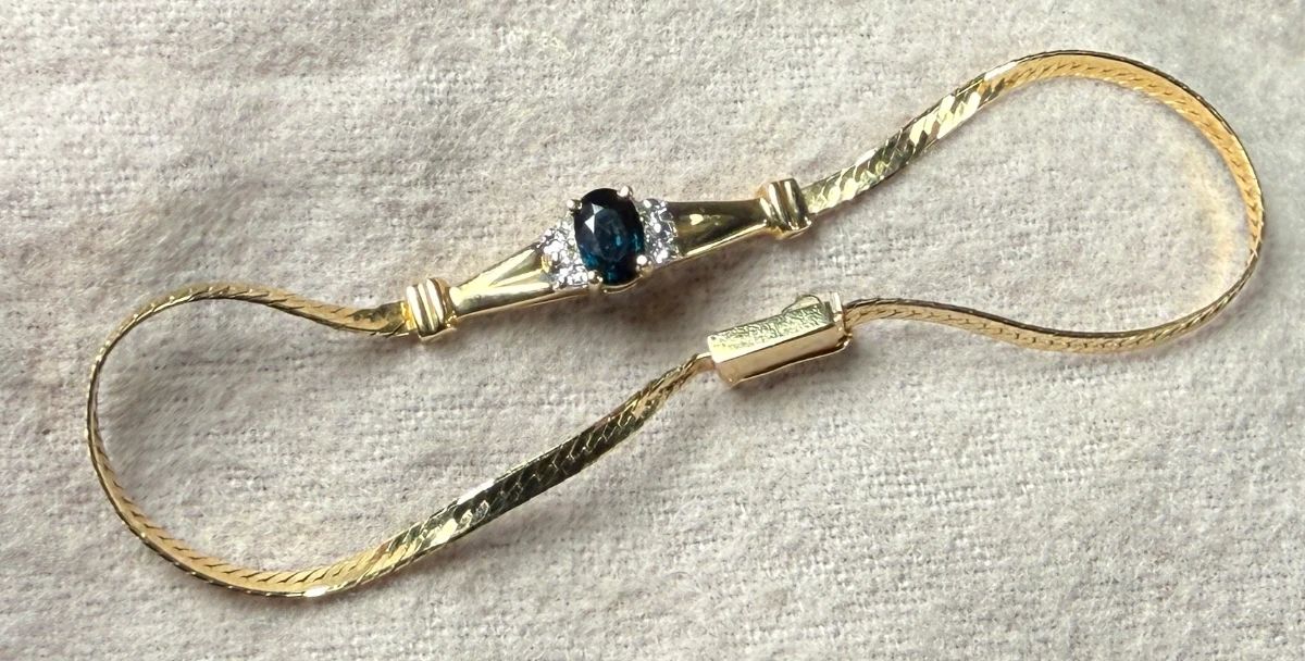 This lot features a stunning 14k gold bracelet with genuine diamonds and what appears to be a sapphire center stone. The bracelet measures, 7” and has a total approx. weight of 3.26 grams.