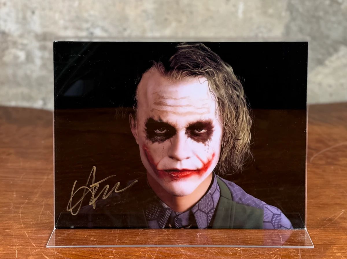 This lot features a signed photograph of actor Heath Ledger, obtained in person on film location of Dark Knight in Chicago, Illinois.