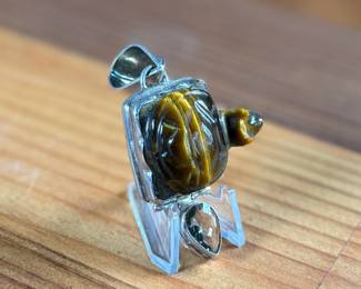 This lot features a vintage pendant with a carved piece of Tiger’s Eye in the shape of a turtle, wrapped in sterling silver. This pendant measures, 2.5” H and has a total approx. weight of 21.97 grams.