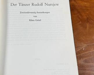 This lot features a rare, pocket-sized collectible book titled “RUDOLF NUREJEW” by German ballet critic Klaus Geitel. The book focuses on the famous ballet dancer Rudolf Nureyev at the height of his career and is signed on the front by Nureyev himself. The book is published by Rembrandt Verlag and comes in good overall condition.