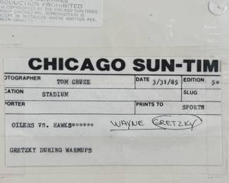 This lot features a vintage photograph of Wayne Gretzky held in a protective sleeve, along with a limited edition commemorative pin set.