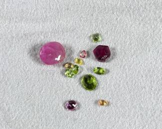 This lot features a collection of semi-precious gemstones including an earth mined sapphire, an earth mined ruby, and many others.