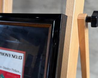 This lot features a professionally framed signed cachet by Russian Composer, Dmitry Shostakovich. Accompanied with a certificate of authenticity. Measures in frame, 25.5” H x 19.75” W.