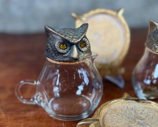 This lot features a vintage owl themed set with two jars manufactured by Ted Arnold Ltd., and a set of four (4) "owl" coasters.