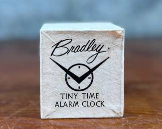 This lot features a vintage Bradley mechanical travel alarm clock, manufactured in Germany and is in good working condition.