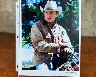 This lot features a signed photograph by actor Heath Ledger and comes with a certificate of authenticity.