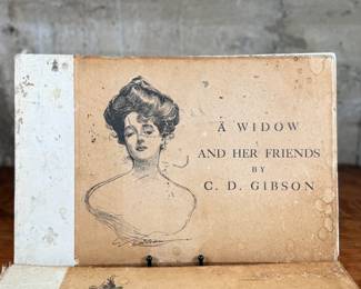 This lot features a pair of antique illustrated books featuring drawings by Charles Dana Gibson. A Widow and Her Friends is a hardcover book published around 1901, featuring the iconic Gibson Girl illustrations. The Education of Mr. Pipp is another collection of Gibson’s works, often bound similarly in large folio formats. 