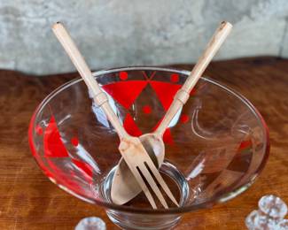 This lot features a rare mid-century Gay Fad "Moon" pattern set circa 1950s featuring atomic-style red and gold triangles and dots. The set includes a clear glass serving bowl, matching wooden serving utensils, and two glass cruets with stoppers. One of the stoppers has damage as shown in photos.